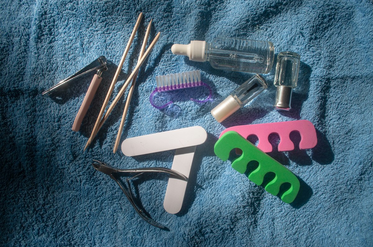 At-home manicure kit laid out on a towel with file, clippers, and polish bottles